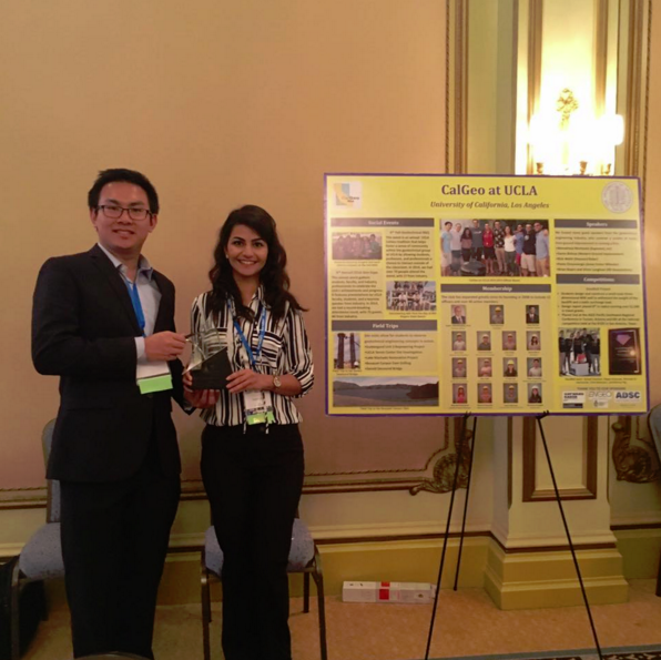 Two people stand to the left of a CalGeo at UCLA poster